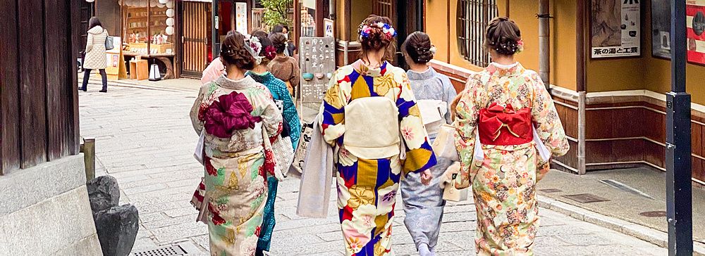 persone in kimono camminano in una strada tradizionale a Kyoto.