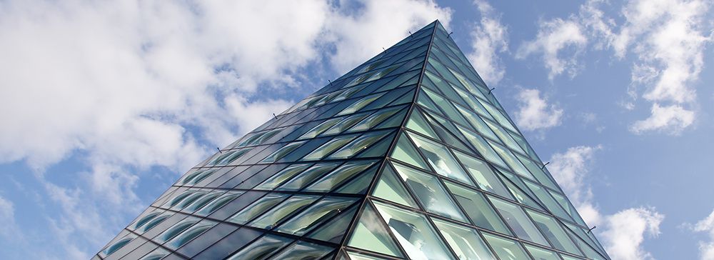 Facciata in vetro dell'edificio Prada Aoyama a Tokyo con cielo blu.