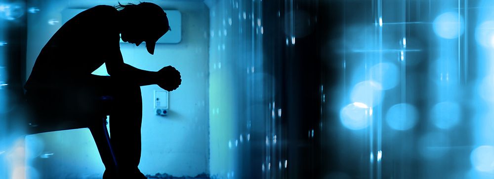 Silhouette di un teenager in preghiera su sfondo blu astratto.