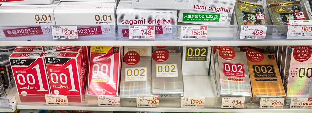 Scaffali di una farmacia in Giappone con confezioni di preservativi esposte in ordine per vendita.