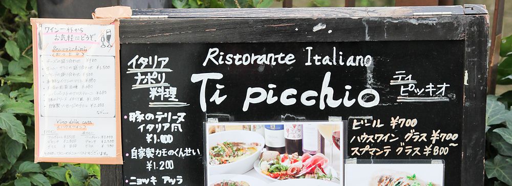 Cartello di un ristorante italiano in Giappone con menu in italiano e giapponese.