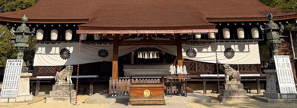 L'edificio principale del Santuario Izanagi sull'isola di Awaji con lanterne in pietra e komainu sotto un cielo sereno.