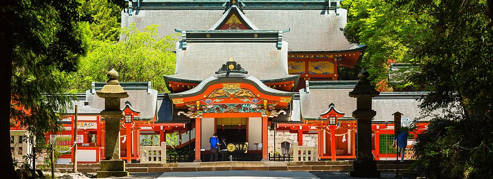 Santuario Kirishima Jingu immerso nel verde con architettura tradizionale in legno rosso e tetti grigi.