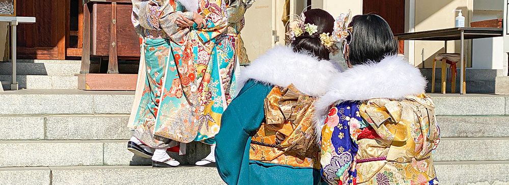 Persone in kimono tradizionale davanti all'ingresso principale del Santuario Namba Yasaka a Osaka.
