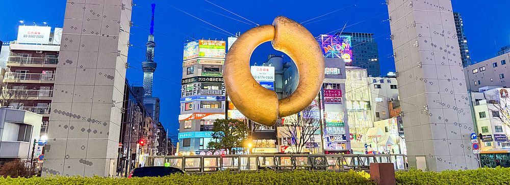 La scultura monumentale a forma di anello dorato si trova nella piazza antistante la stazione di Kinshicho a Tokyo.