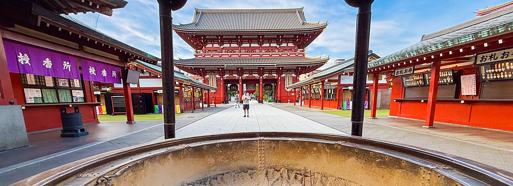 Persona davanti al tempio Senso-ji ad Asakusa, Tokyo, con grande braciere in primo piano.
