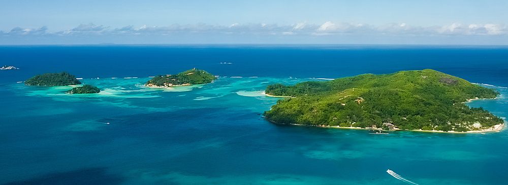 Vista aerea delle isole Seychelles tra acque turchesi e verde vegetazione.