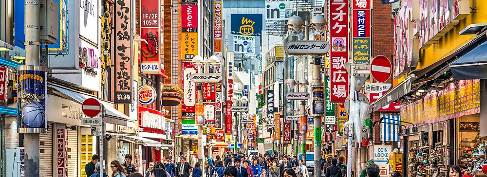 Shibuya Cener-gai a Tokyo con folla e insegne colorate di giorno.