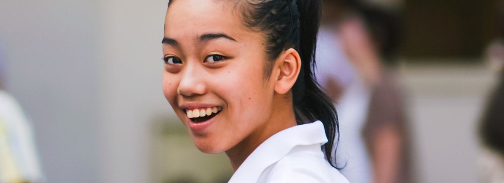 Giovane donna sorridente con camicia bianca a Shibuya.
