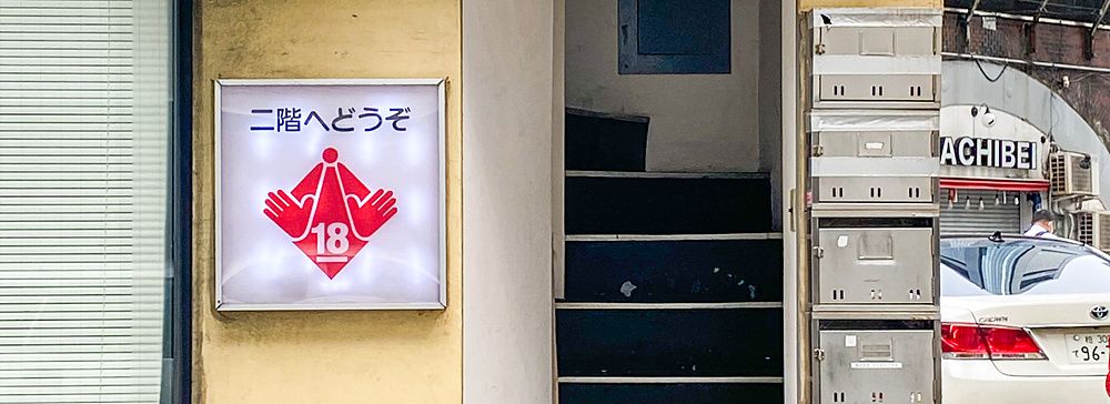 Ingresso di un locale per adulti a Shimbashi, Tokyo, con scala stretta.