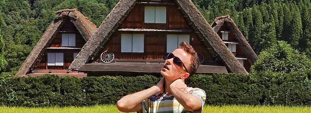 Persona in un campo di riso con case Gassho-zukuri sullo sfondo a Shirakawa-go.