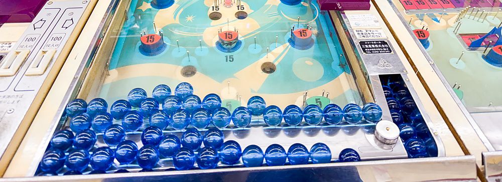 Macchine da gioco vintage in stile flipper con biglie blu presso la sala giochi Smartball New Star a Osaka.