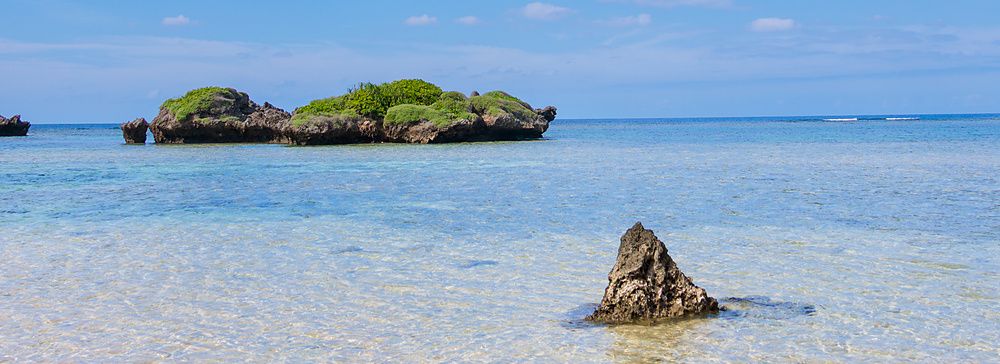 Veduta della spiaggia Hoshizuma sull'isola di Iriomote con formazioni rocciose che emergono dalle acque limpide del mare.