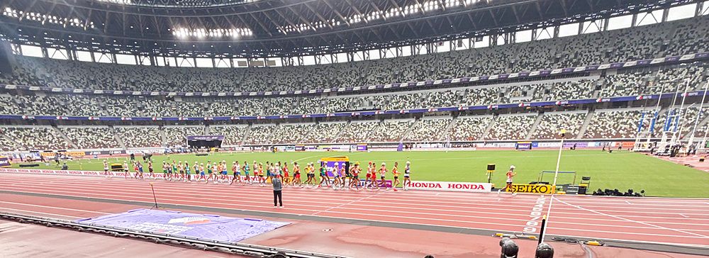 Marco Togni con una bandiera italiana fa un selfie all'interno allo Stadio Nazionale Giapponese a Tokyo durante una gara.