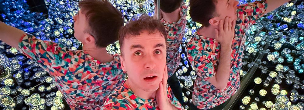 Marco Togni nella stanza delle lanterne a teamLab Borderless Tokyo, circondato da luci riflettenti.