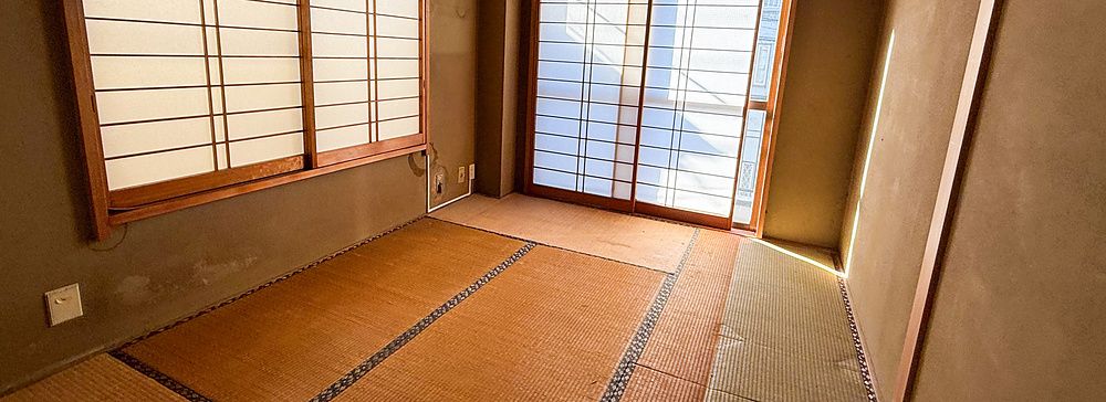 Stanza giapponese con tatami e shoji illuminata dalla luce naturale.