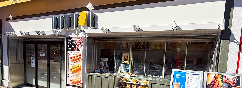 Esterno di un punto vendita Doutor Coffee presso una stazione di servizio in autostrada in Giappone con menu esposti.