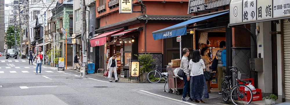 Strada urbana nel quartiere di Ningyocho a Tokyo con edifici in stile tradizionale e insegne in giapponese.