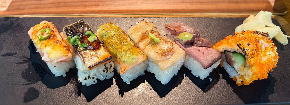 Sushi aburicious servito su piatti rettangolari presso il ristorante Kinka Sushi Bar Izakaya nel quartiere di Shibuya.