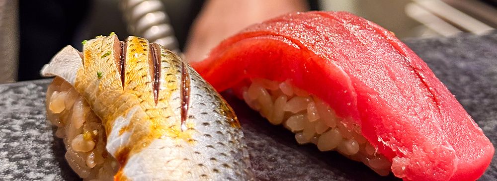 Kohada e tonno serviti su un piano scuro al Kaiten Sushi Ginza Onodera, nel quartiere Omotesando di Tokyo.