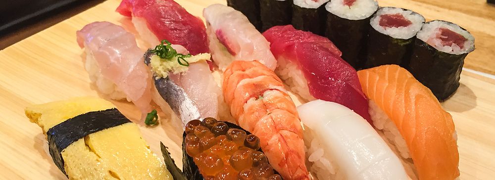Una varietà di nigiri e hosomaki disposti su un tagliere di legno al Tama Sushi a Tachikawa.
