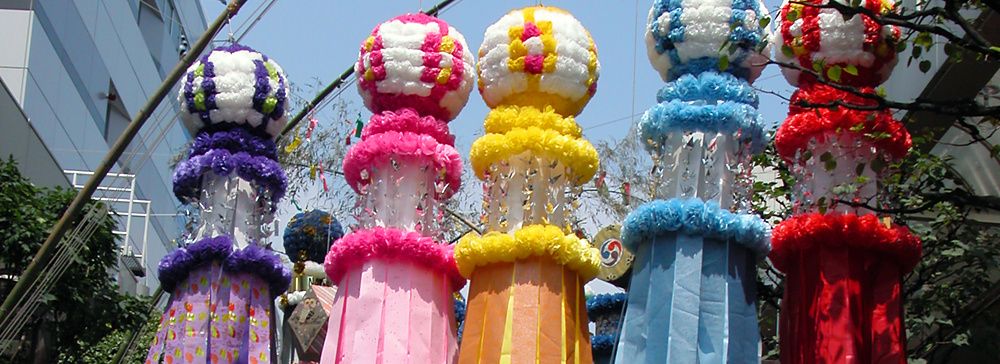 Decorazioni colorate del Tanabata festival a Sendai, Giappone, con persone che passeggiano sotto.