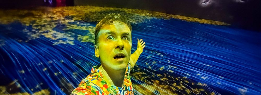 Marco Togni in una sala immersiva a teamLab Borderless Tokyo con luci colorate.