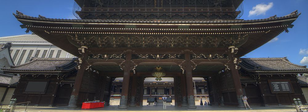 Facciata del tempio Higashi Hongan-ji a Kyoto sotto un cielo azzurro.