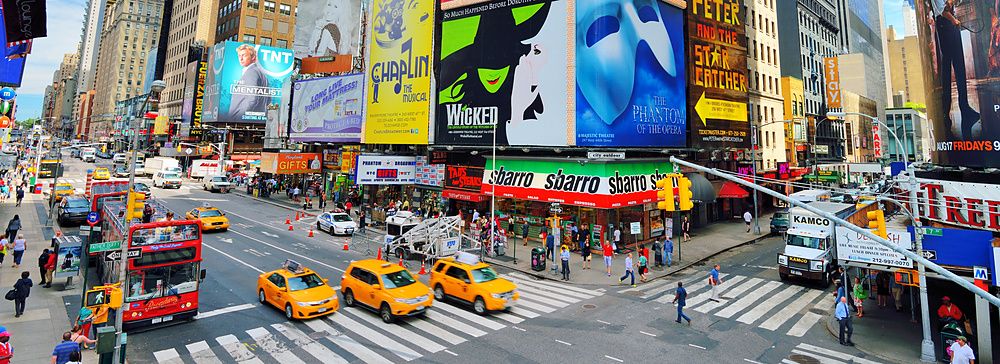 Scena vivace di Times Square a New York con traffico e cartelloni pubblicitari.