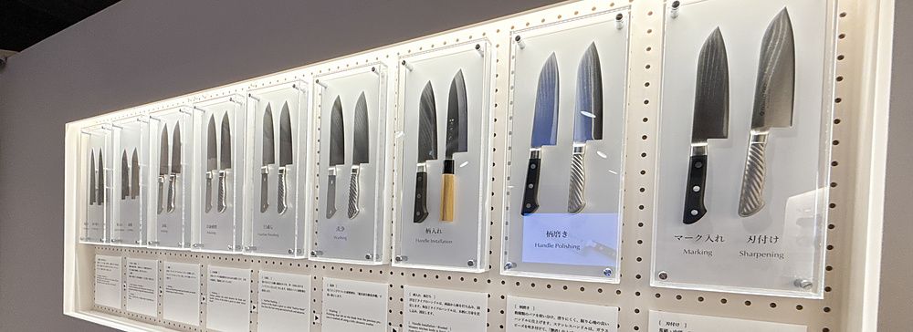 Esposizione di coltelli giapponesi con didascalie tecniche presso Tojiro Knife Gallery a Sennichimae Doguyasuji, Osaka.