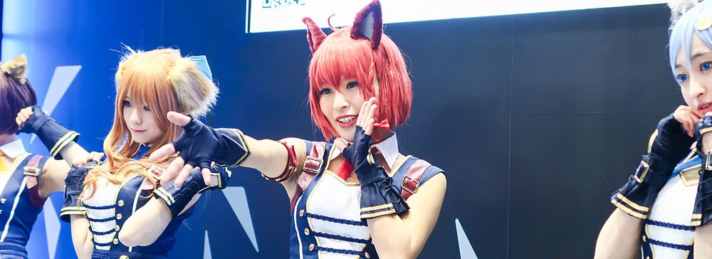Tre persone indossano costumi da cosplay ispirati ad anime con orecchie da animale durante la Tokyo Anime Fair.