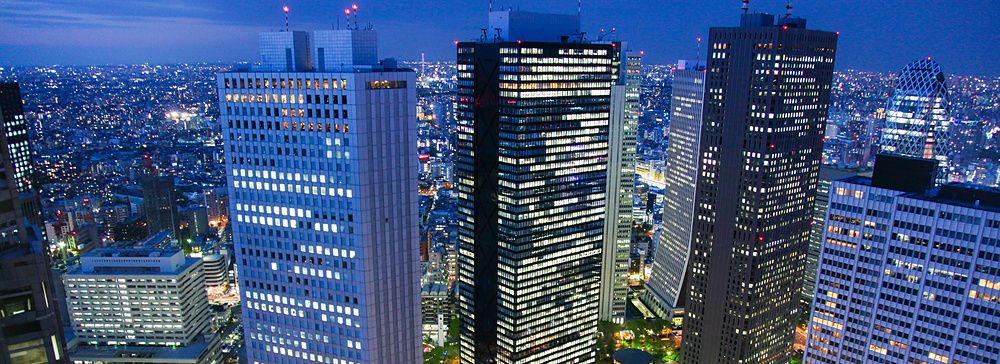 Vista notturna di Tokyo dall'alto con grattacieli illuminati.