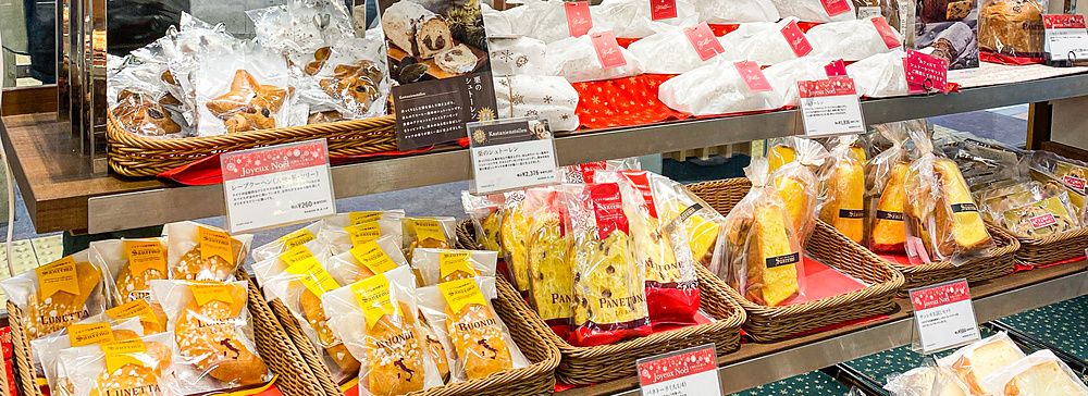 Scaffali di prodotti da forno e panettoni natalizi in vendita presso la panetteria Donq.