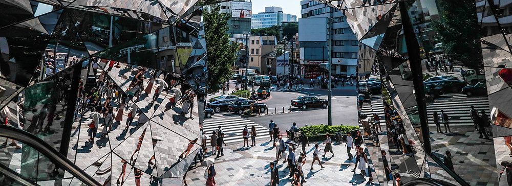 Veduta caleidoscopica attraverso gli specchi dell'ingresso del Tokyu Plaza ad Harajuku, con persone che camminano in strada.