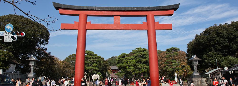 Torii rosso al Santuario Tsurugaoka Hachiman a Kamakura con persone intorno.