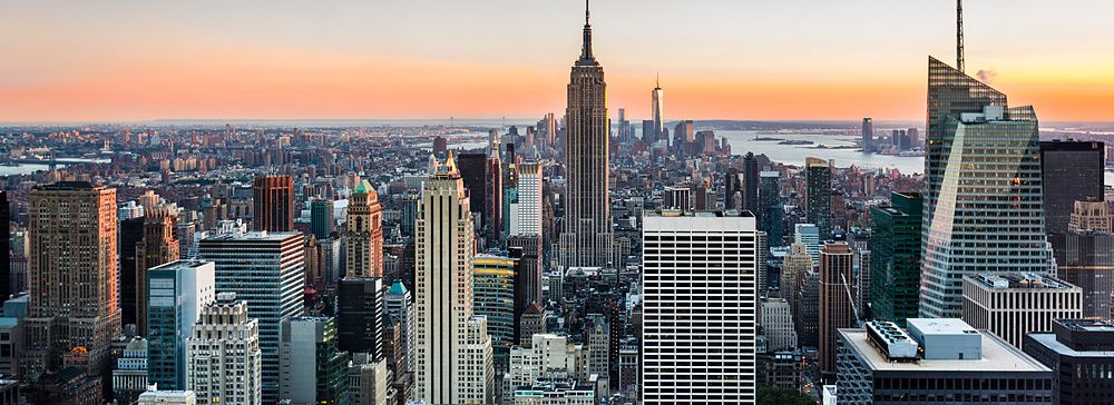 Skyline di New York al tramonto con Empire State Building e grattacieli.