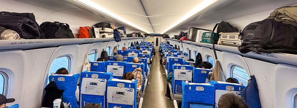 passeggeri seduti all'interno di un treno shinkansen.