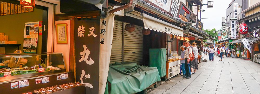 Via commerciale tradizionale a Shibamata con negozi e persone.