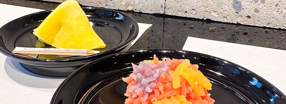 Due wagashi a Tsuruya Yoshinobu serviti su piatti neri all'interno della sede di Nihonbashi.
