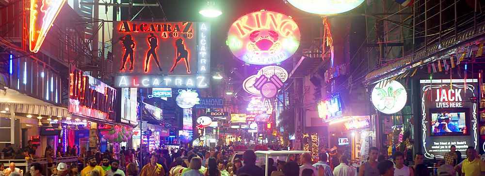 Walking Street a Pattaya affollata di notte con insegne al neon e persone.