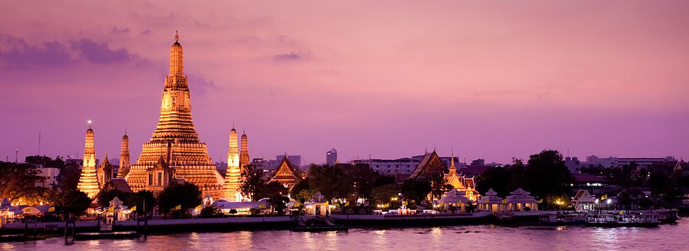 Wat Arun illuminato al tramonto, vista sul fiume Chao Phraya, Bangkok.