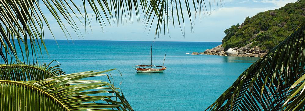 Yacht di lusso in mare turchese tra palme a Koh Samui, Thailandia.