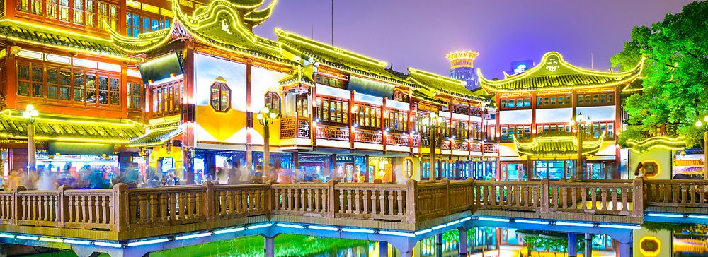 Edifici illuminati a Yuyuan Gardens di Shanghai riflessi nell'acqua.