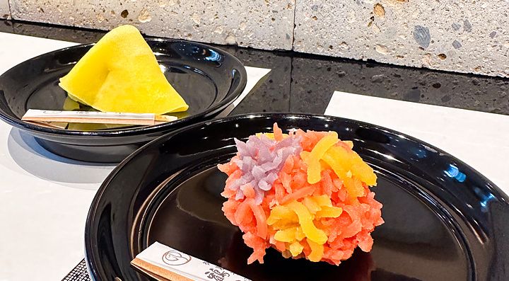 Due wagashi a Tsuruya Yoshinobu serviti su piatti neri all'interno della sede di Nihonbashi.