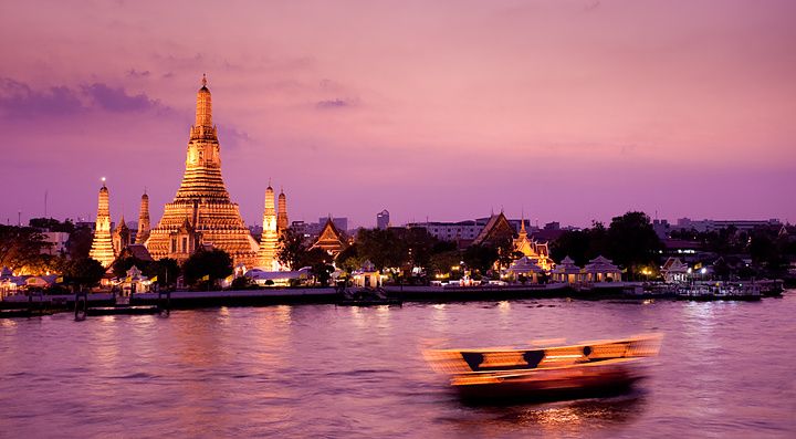 Wat Arun illuminato al tramonto, vista sul fiume Chao Phraya, Bangkok.
