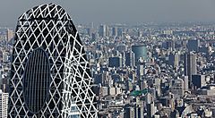 La parte alta della Cocoon Tower in primo piano, e sullo sfondo la città di Tokyo.