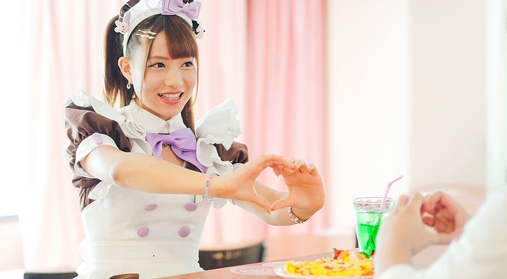Cameriera in uniforme carina che serve un cliente in un home café.