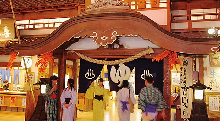 Persone in yukata all'ingresso dell'Oedo Onsen Monogatari.