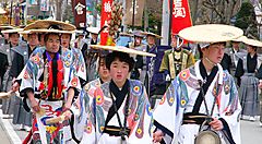 Persone in abiti tradizionali giapponesi sfilano durante un festival culturale.