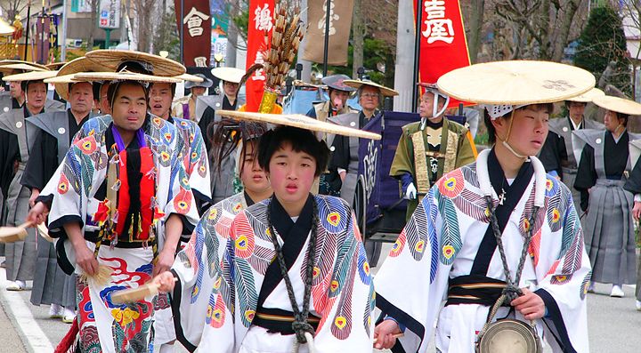 Persone in abiti tradizionali giapponesi sfilano durante un festival culturale.